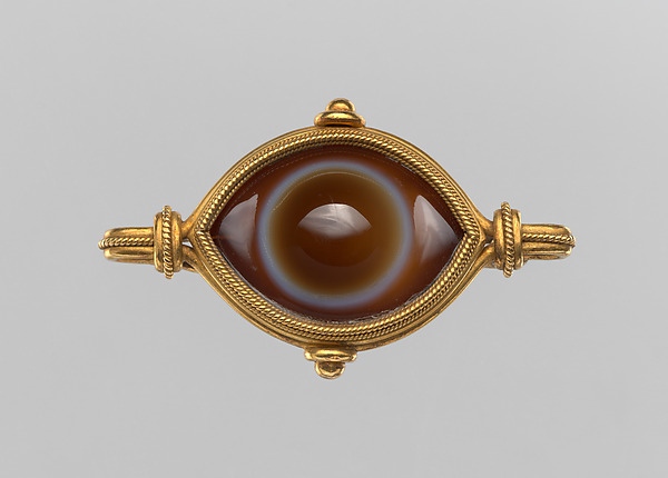A bold and sculptural 'Trombino' ring set with a Colombian emerald within a diamond surround.
